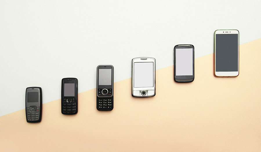 A side by side comparison of cell phones ranging from old to new, representing the modernization of technology